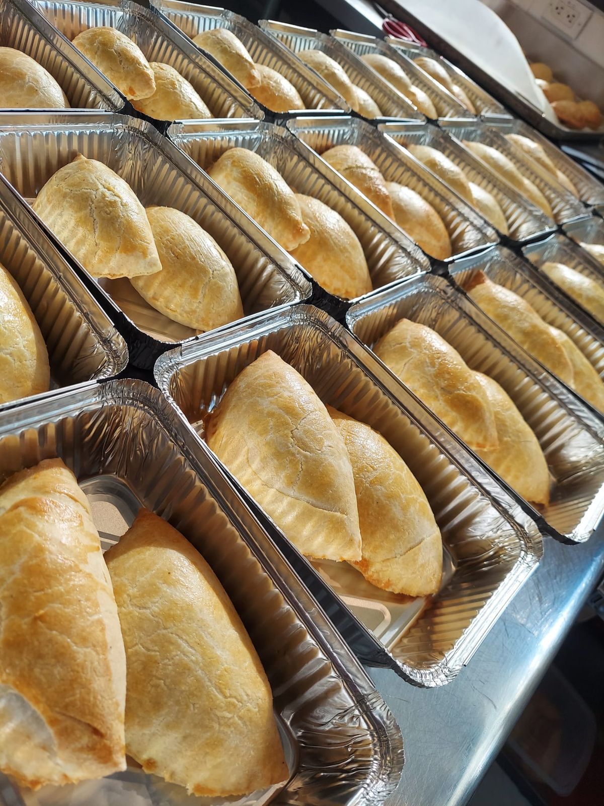 Freshly baked Nigerian meat pies in a tray by Metheq Cuisine