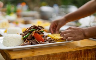 Chef plating a fresh Nigerian catering order